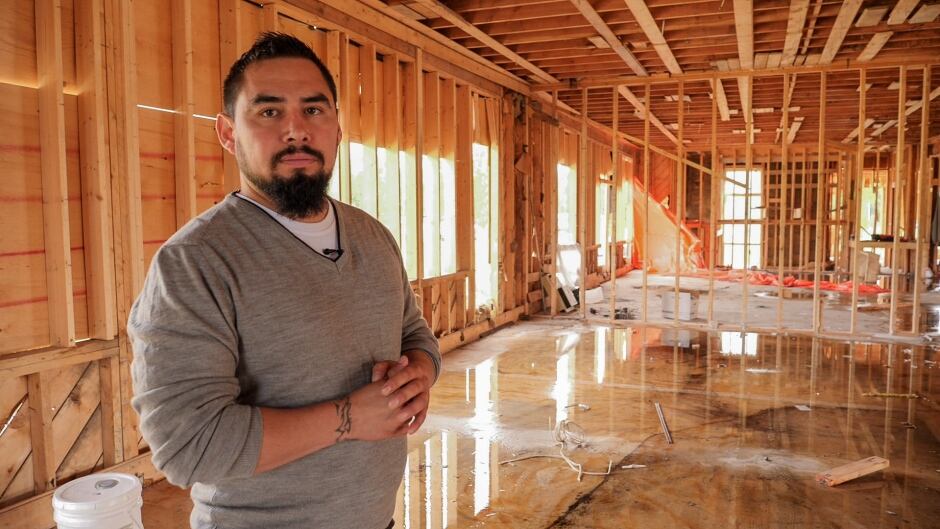 Harlan Schilling standing in a flooded construction site for a new home.